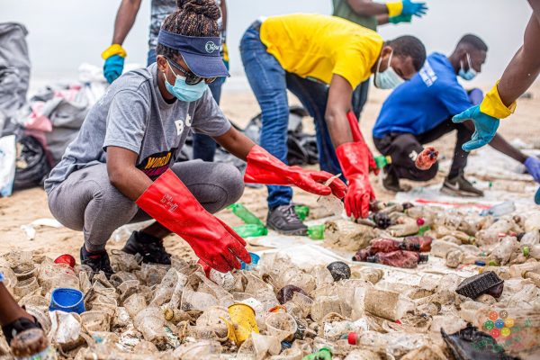 A clean-up crew gathering garbage on a beach for World Clean Up Day