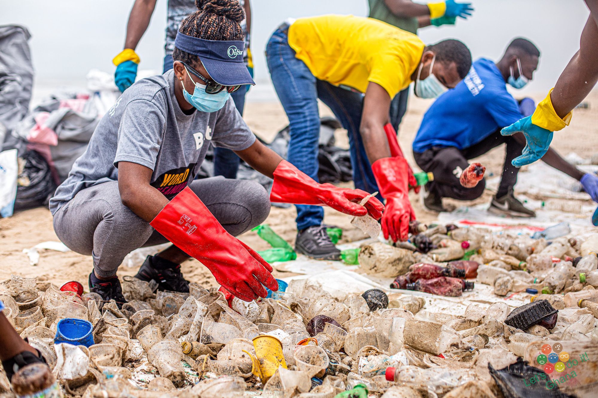 A clean-up crew gathering garbage on a beach for World Clean Up Day