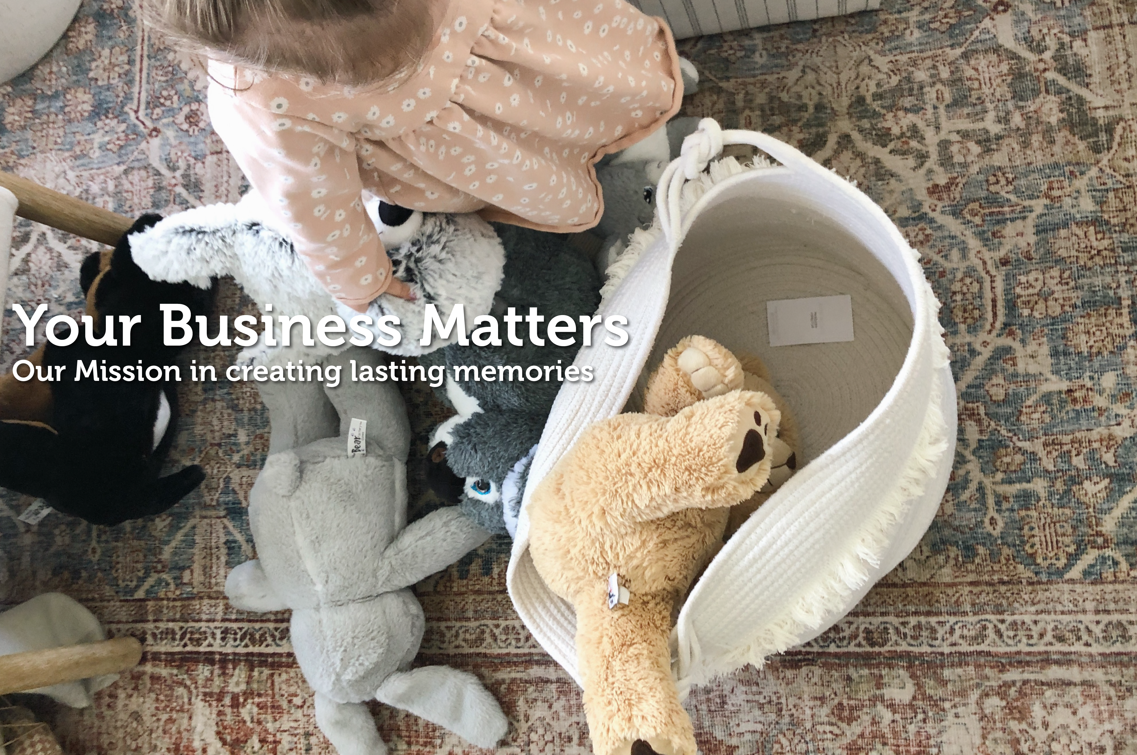 A photo of a child with a basket of plush buddies taken from above, with white text that says "your business matters. Our mission in creating lasting memories"