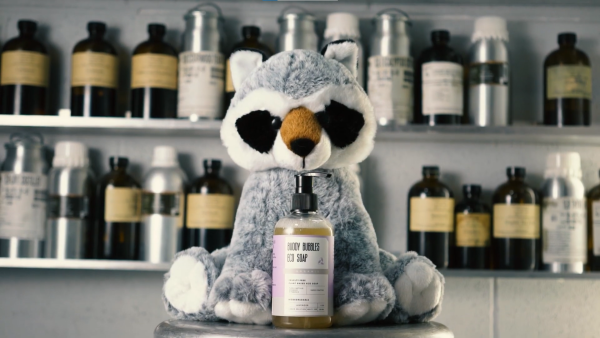 A plush animal with a bottle of plush care line bears and buddies soap